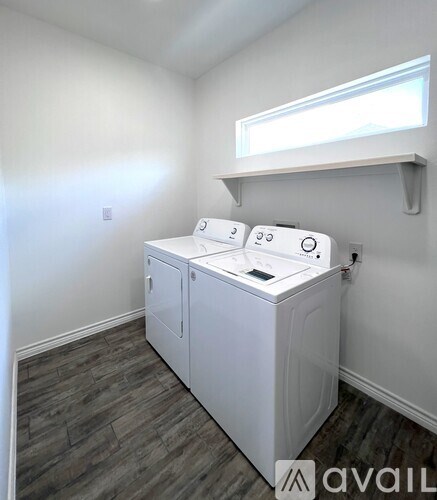 A washing machine is sitting in a laundry room.