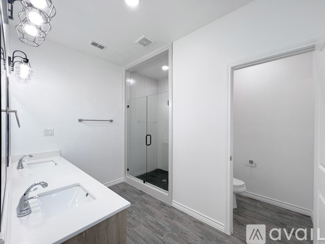 A bathroom with a white sink and a walk-in shower.