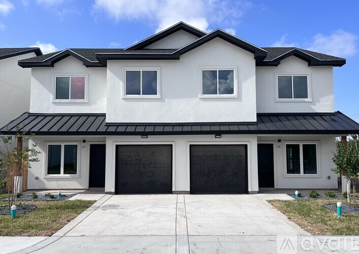 A modern two-story house with a black roof and white walls.