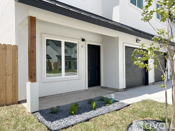 A modern house with a white exterior and a black roof.