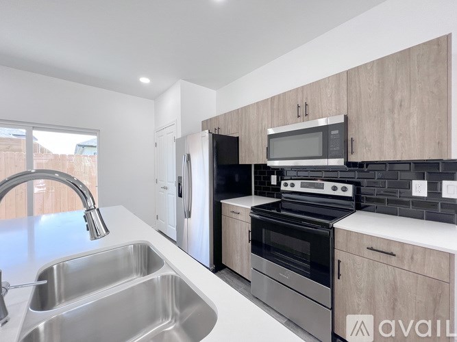 A modern kitchen with stainless steel appliances and wooden cabinets.