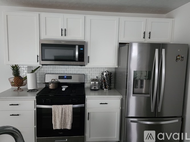 A kitchen with white cabinets and a black stove top.