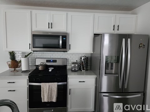 A kitchen with white cabinets and a black stove top.