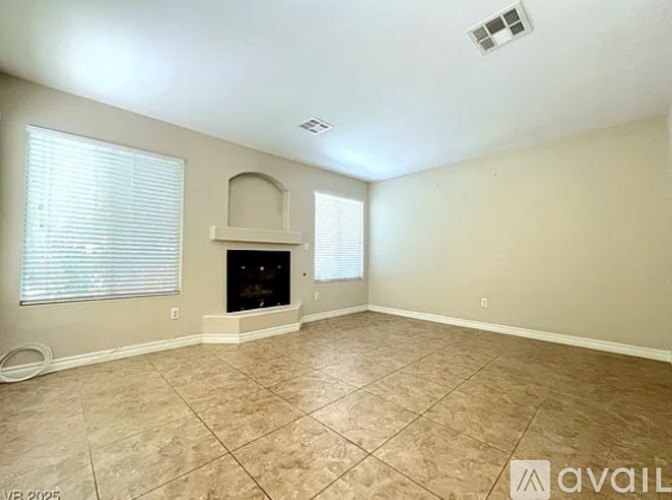 A living room with a fireplace and a window with blinds.