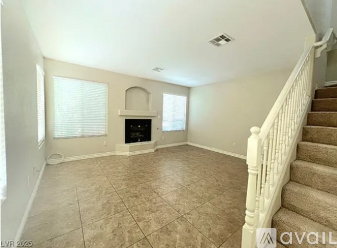 A living room with a fireplace and a staircase.