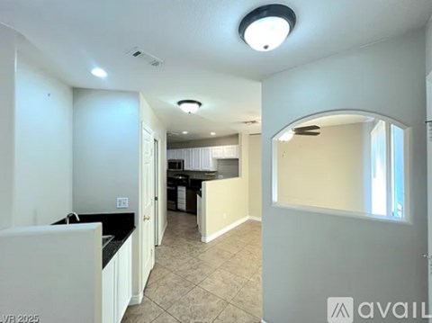 A kitchen with white cabinets and a black countertop is shown.