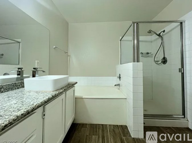 A bathroom with a white tub and a walk-in shower.