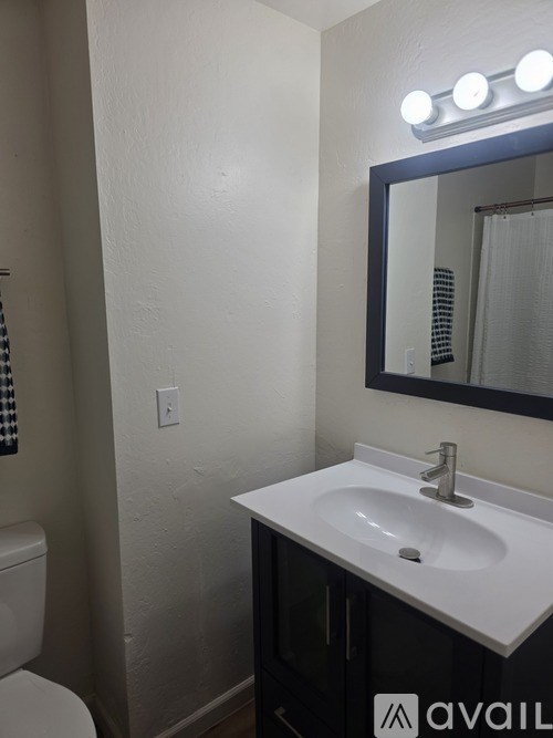 A bathroom with a white sink and a mirror above it.