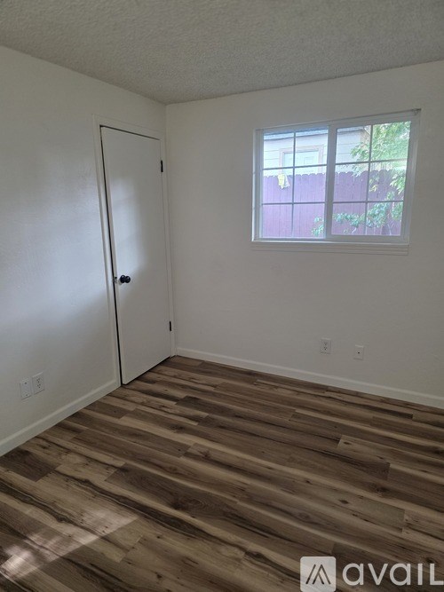 A room with a wooden floor and a window.