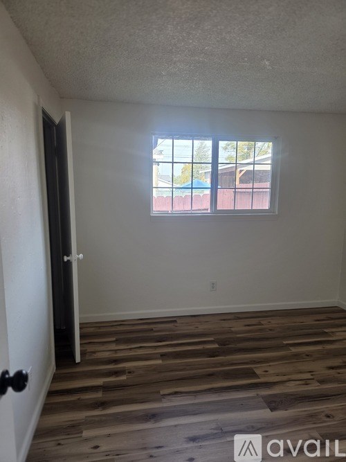 A room with wooden flooring and a window.