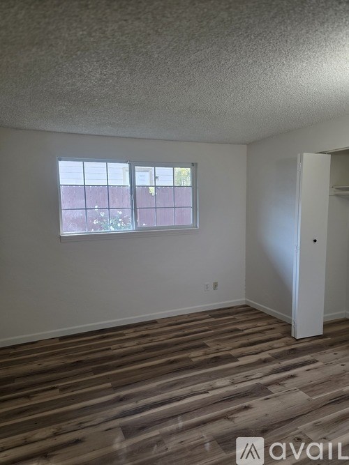 A room with a window and wooden flooring.