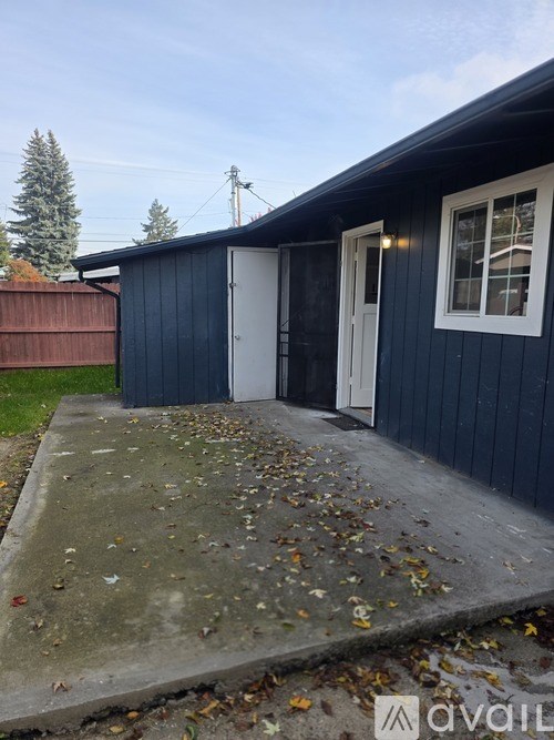 A small blue building with a white door and a window.