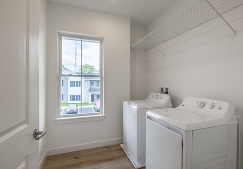 A laundry room with a washer and dryer and a window.
