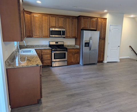 A kitchen with wooden cabinets and a granite countertop.