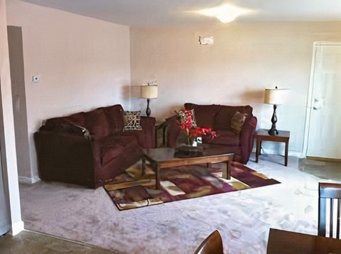 A living room with a red couch and a coffee table.