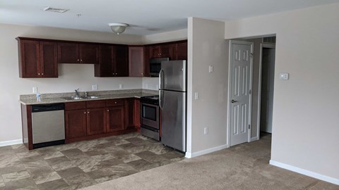 A kitchen with brown cabinets and a refrigerator.