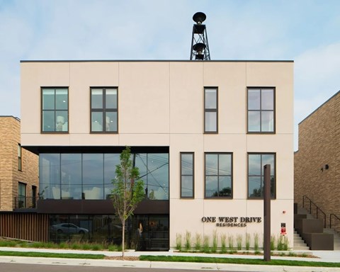 A building with a sign that says "One West Drive Residences" on the side.