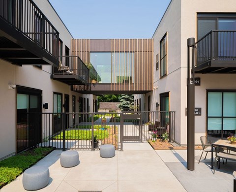 A modern building with a black metal fence and a glass door.
