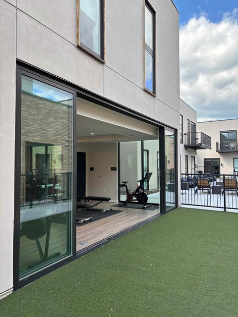 A modern house with a balcony and a green lawn.