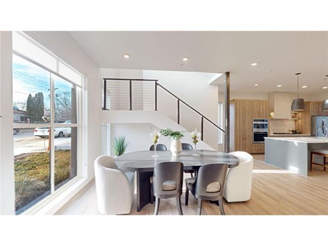 A modern dining room with a glass table and chairs.