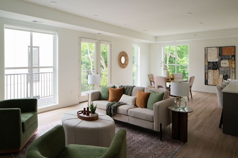 A living room with a green chair and a white couch.