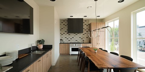 A kitchen with a long wooden table and chairs.