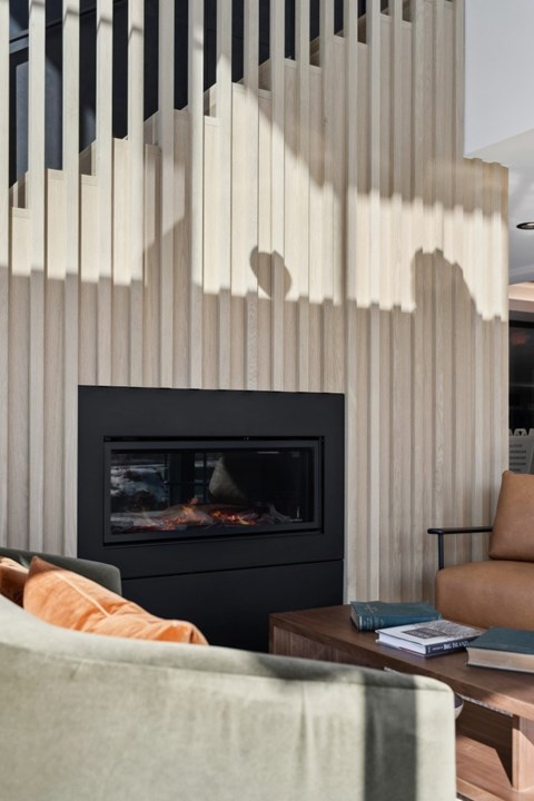 A modern living room with a fireplace and a chair.