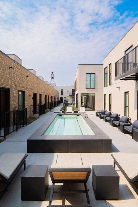 A pool surrounded by black and white furniture.