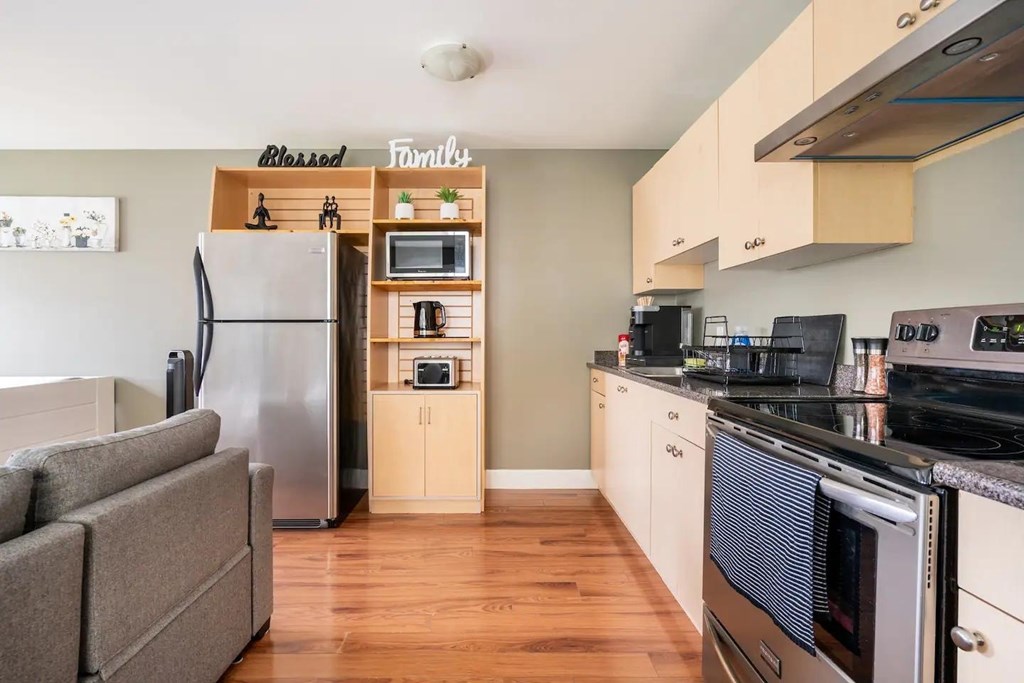 A kitchen with a refrigerator, oven, and microwave.