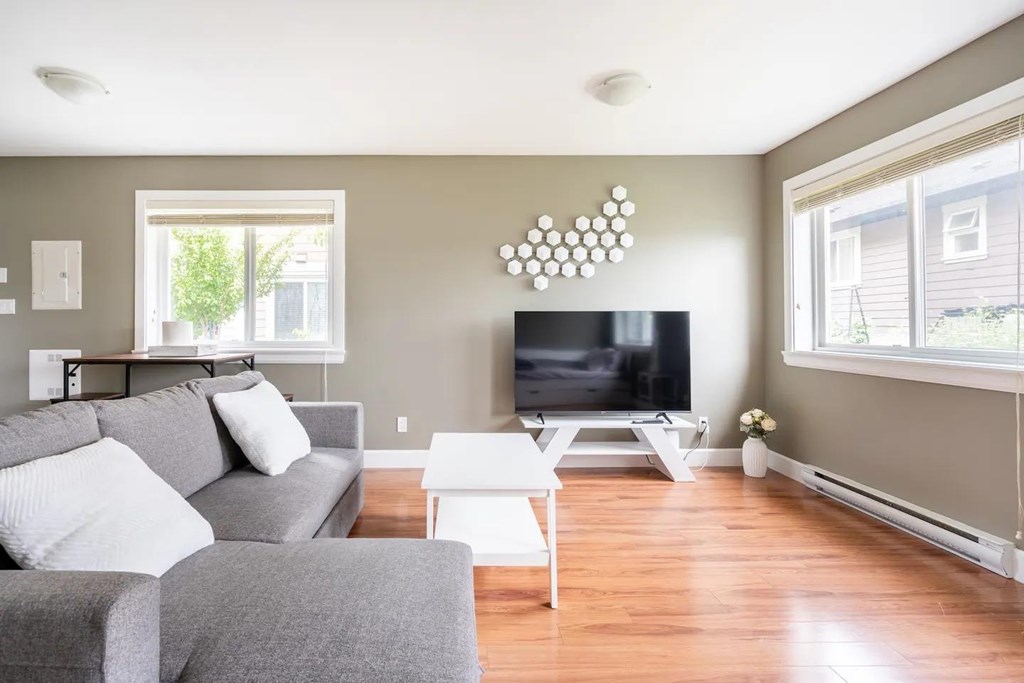 A living room with a grey couch and a white coffee table.