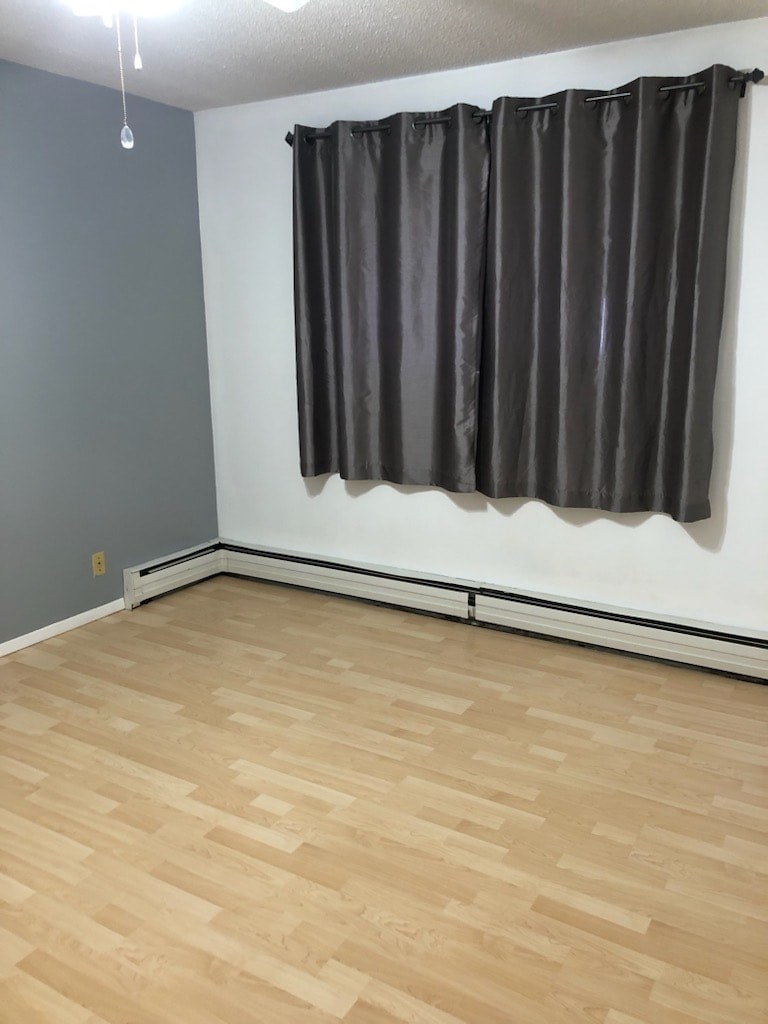 A room with a grey curtain and wooden floor.