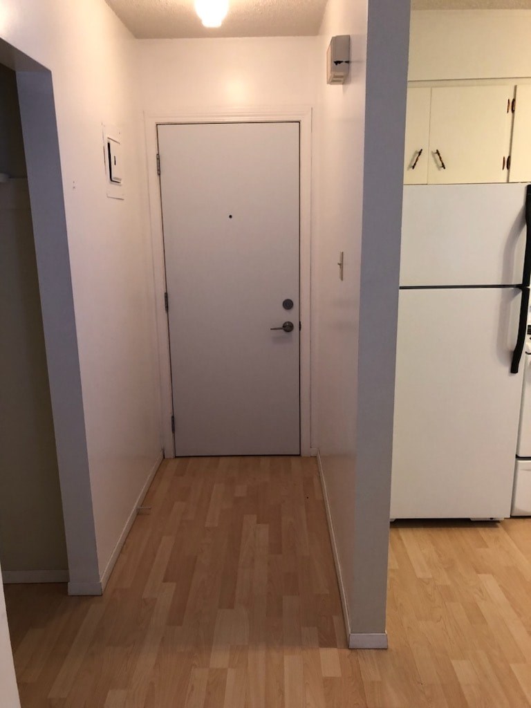 A white door is in a room with wood flooring.