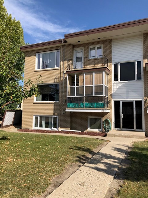 A two-story apartment building with a balcony on the second floor.