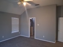 A room with a ceiling fan and a door.