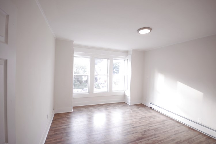 A room with a window and wooden floors.