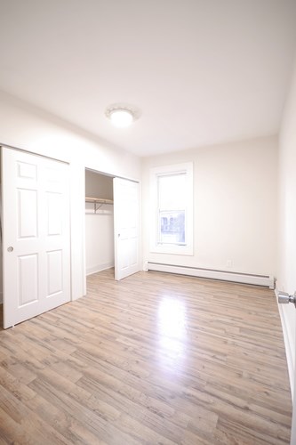 A room with a white door and a window with a white frame.