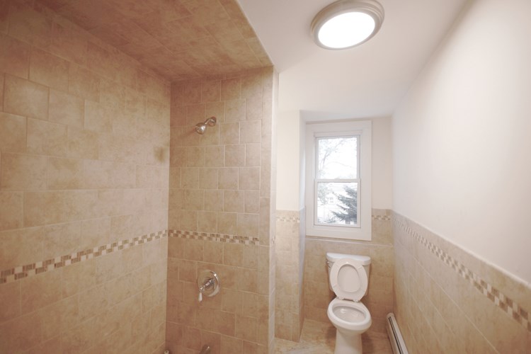 A bathroom with a toilet and a shower.