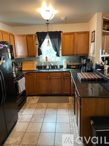 A kitchen with wooden cabinets and black appliances.