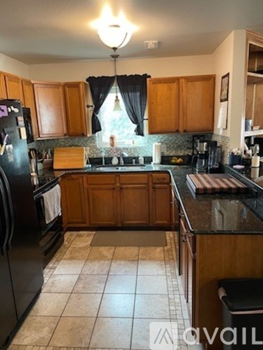 A kitchen with wooden cabinets and black appliances.