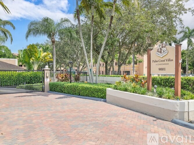 The entrance to Palm Crest Villas is marked by a sign and a gate.
