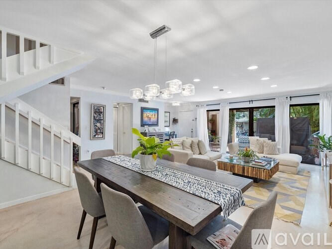 A modern dining room with a wooden table and chairs.