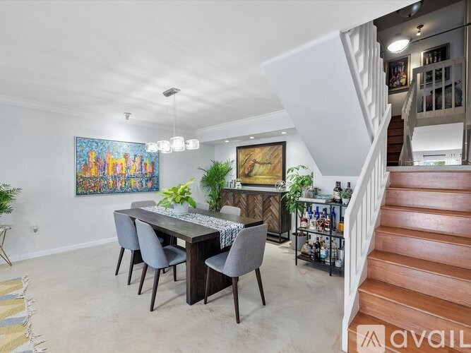 A dining room with a wooden table and grey chairs.