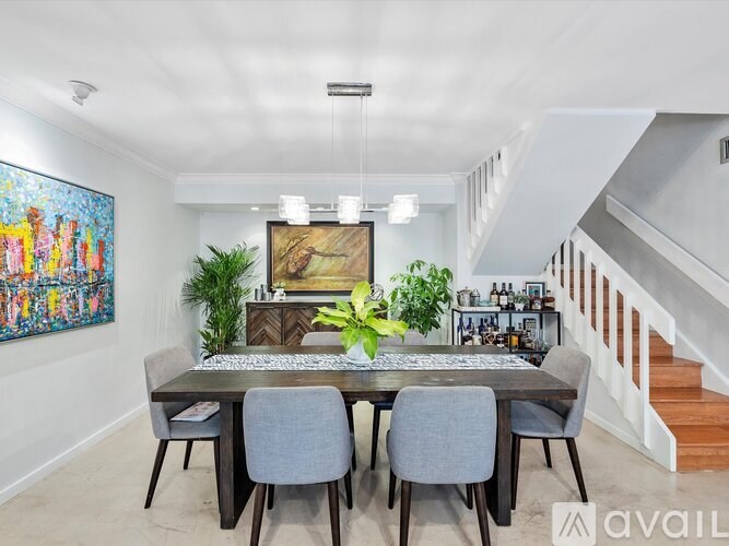 A dining room with a wooden table and grey chairs.