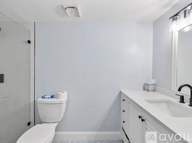 A white toilet with a blue and white container on top of it.