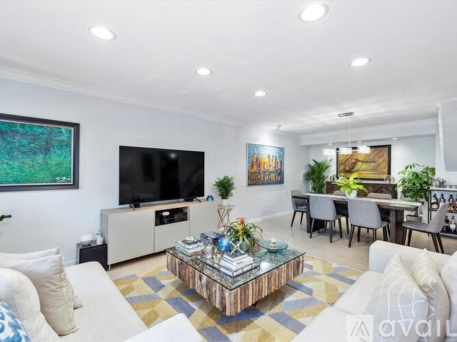 A living room with a white couch and a coffee table in the center.