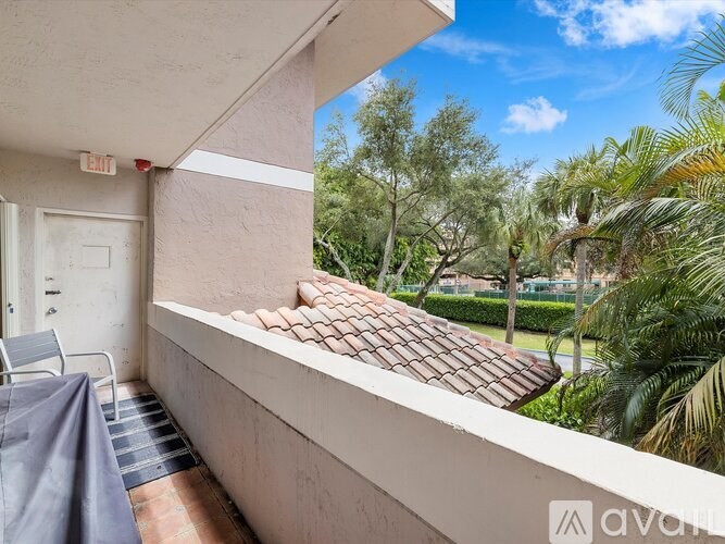 A balcony with a grey chair and a grey blanket over it.
