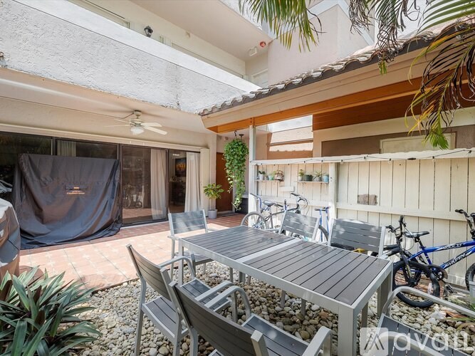 A patio with a table and chairs is covered with a grey tarp.