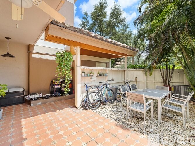A patio with a table and chairs and bicycles.