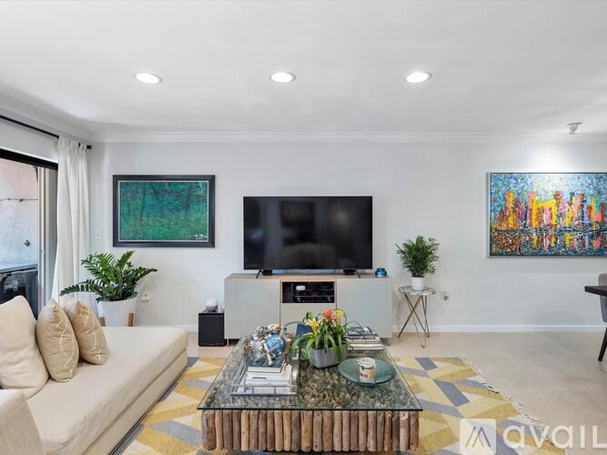 A living room with a couch, a coffee table, and a television.