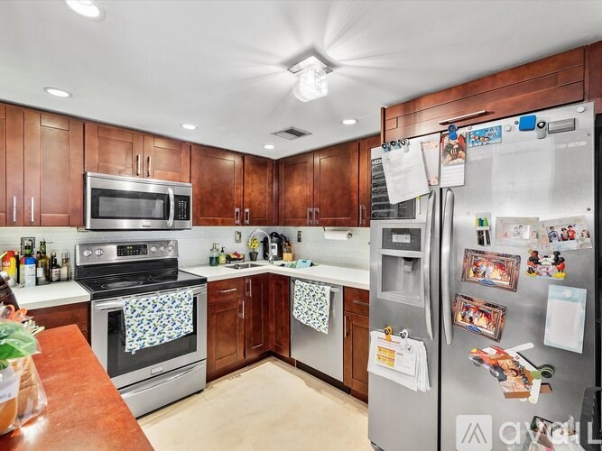A kitchen with a refrigerator covered in paper and magnets.